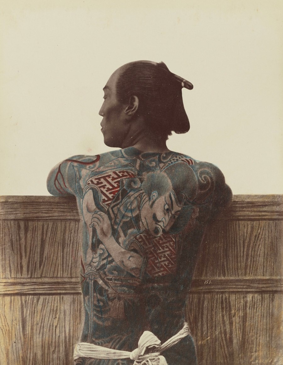 رجل ياباني يظهر للمصور الوشم الذي يغطي الكثير من جسده في (يوكوهاما) حوالي عام 1890