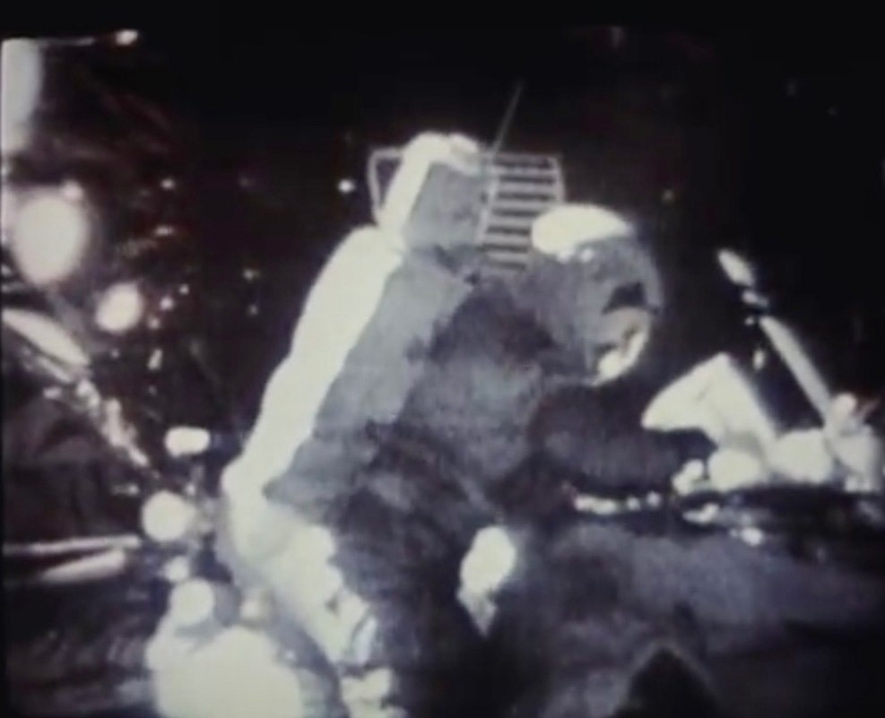 صورة لـ(ديفيد سكوت) على سطح القمر وبحوزته الصندوق السابق وهو يقوم بفتح البريد.