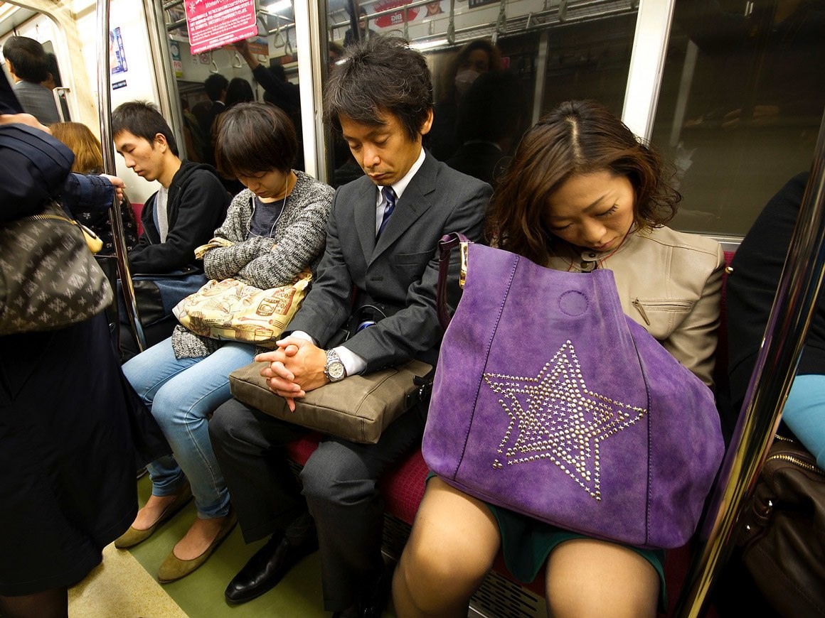 موظفون يابانيون مرهقون من ساعات العمل الطوال نائمون في القطار