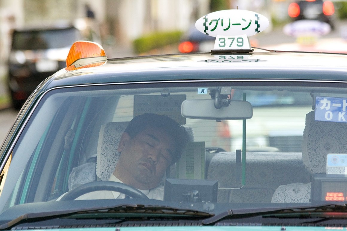 يأخذ سائق التاكسي هذا قيلولة خفيفة على متن سيارته في اليابان.
