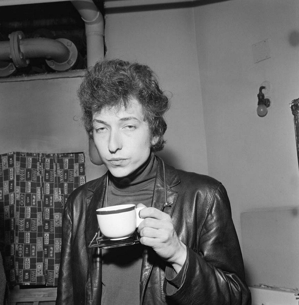 (بوب ديلان) يرتشف كوب شاي خلف الكواليس خلال حفله الشهير الذي أحياه في قاعة عرض (فري ترايد هول) في مدينة (مانشستر) سنة 1965.
