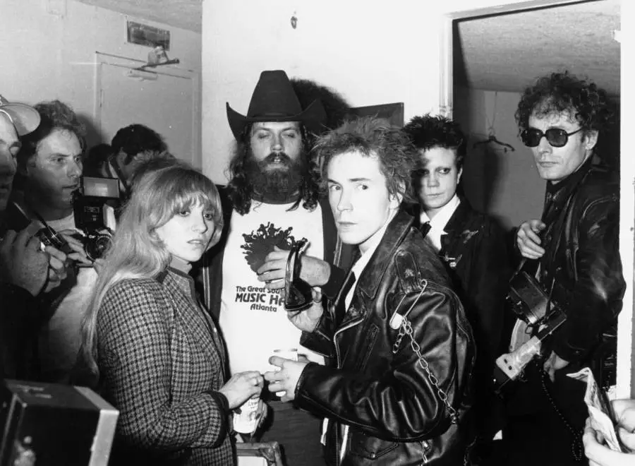 (جوني روتن) المغني الرئيسي في فرقة (سيكس بيستولز) [يرتدي السترة الجلدية في الأمام] يحيي بعض المعجبين خلف الكواليس بعد آخر حفل تحييه الفرقة في سان فرانسيسكو سنة 1978.