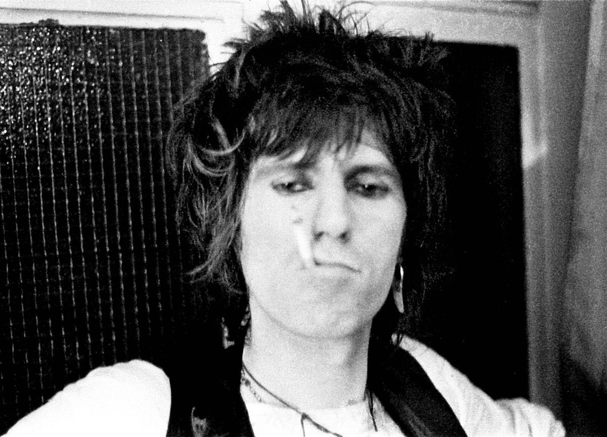 (كيث ريتشاردز) عازف الغيتار في فرقة (رولينغ ستونز) يدخن سيجارة خلف الكواليس سنة 1974.