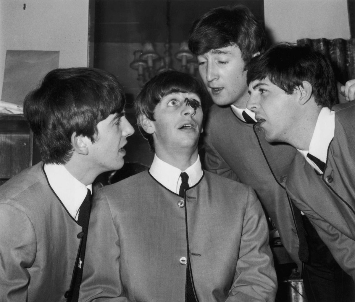أعضاء فرقة الـ(بيتلز)، وهم (جورج هاريسون) و(جون لينون) و(بول مكارتني) يحدقون إلى عنكبوت بلاستيكي وضع فوق أنف طبال الفرقة (رينغو ستار)، وذلك بعد حفل أحيوه في مهرجان مسرح الـ(بالاديوم) في لندن سنة 1963
