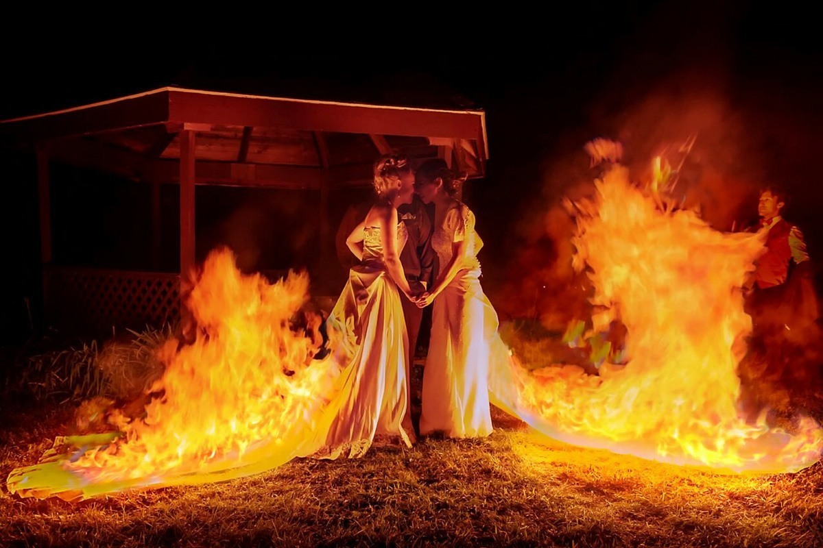 صورة تظهر فيها العروسان وهما ترتديان فستانين مختلفين خلال المراسم قبل إشعال النار