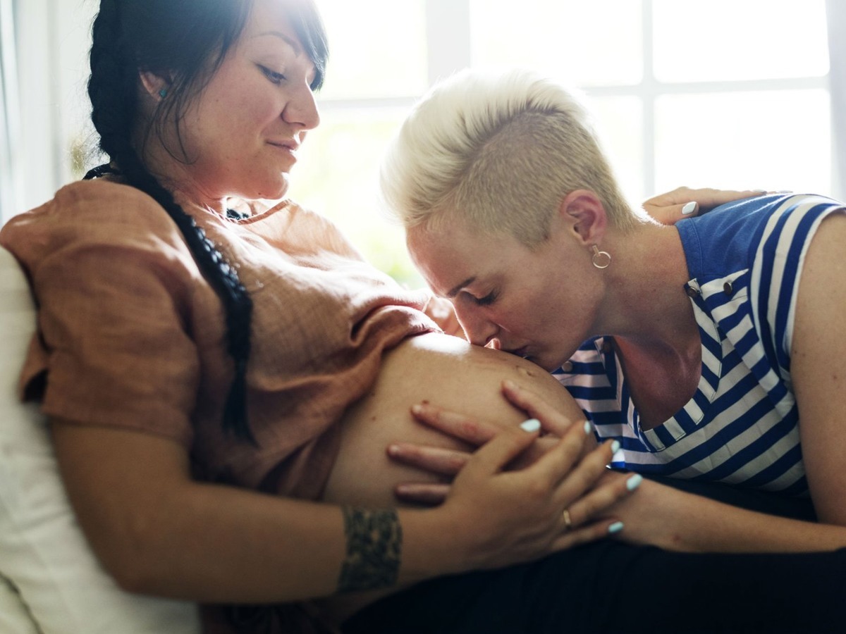 امرأة حامل وشريكها الذي يقبل بطنها