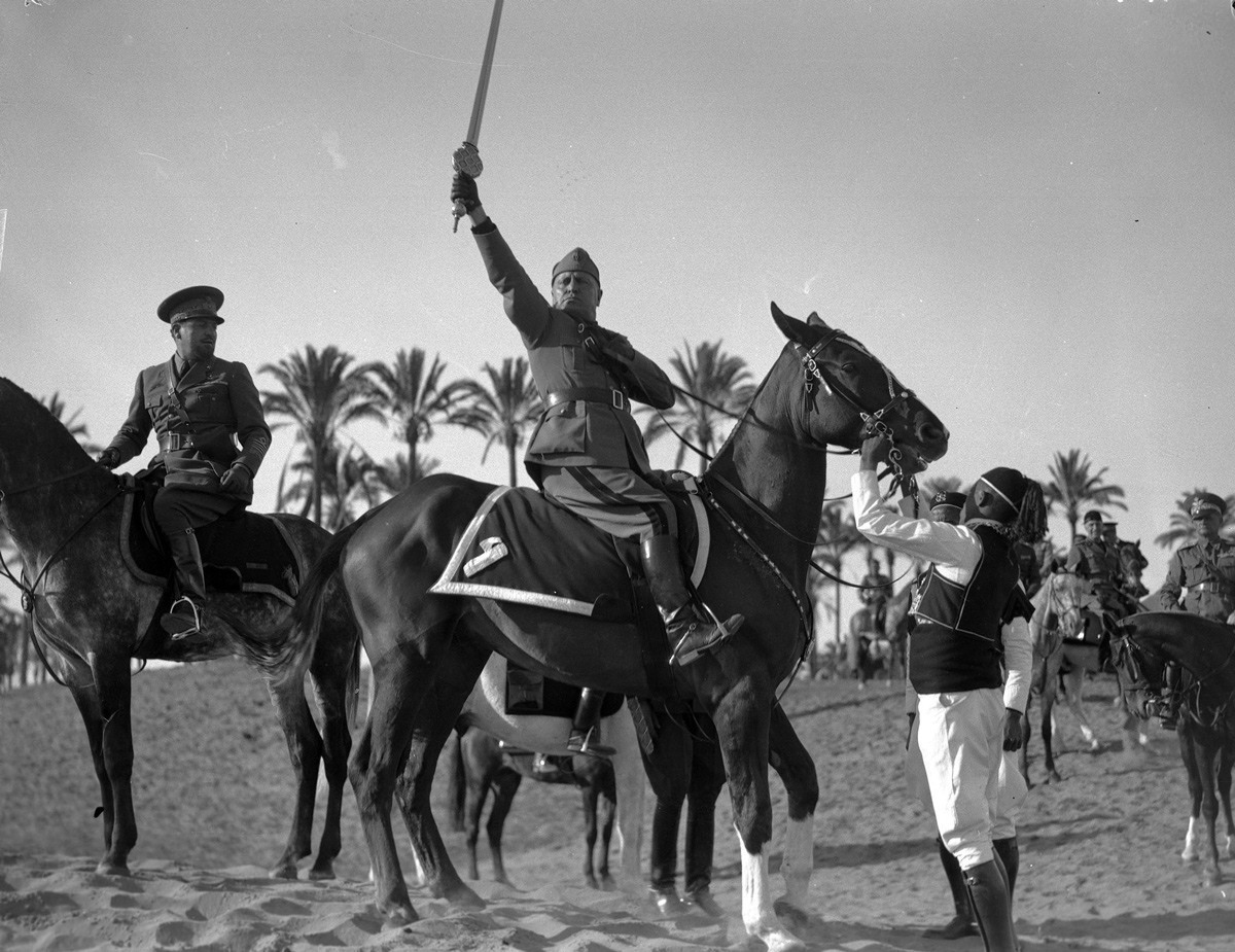 (بينيتو موسوليني) يلوح بـ”سيف الإسلام“ قرب طرابلس، في ليبيا.