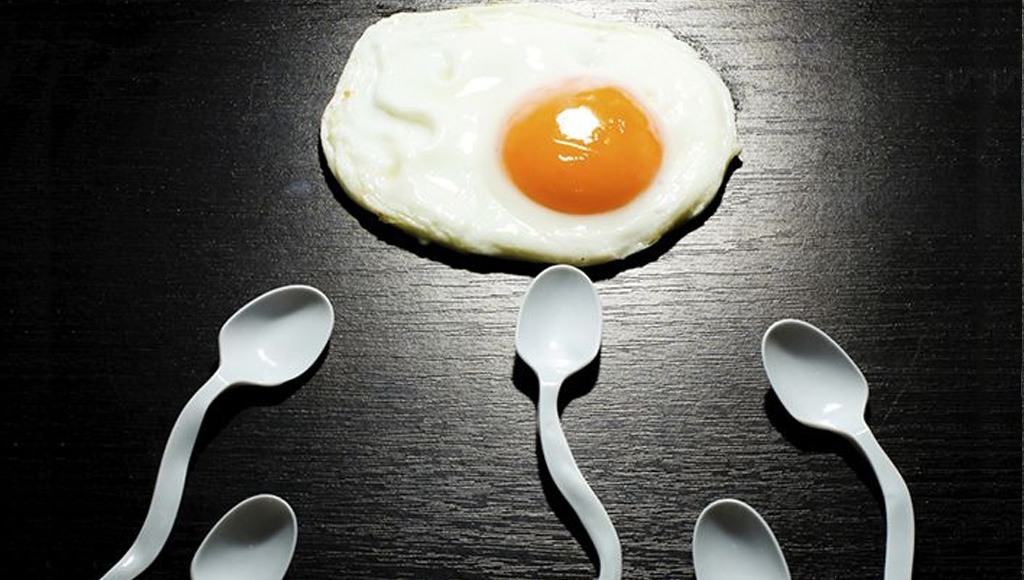 بيضة مخفوقة تحيط بها ملاعق تشبه النطاف