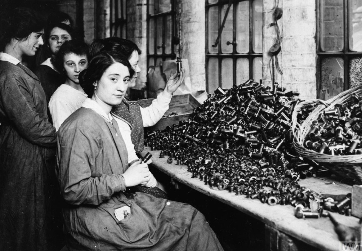 نساء يعملن على الذخيرة في مصنع للذخيرة في مكان مجهول في بريطانيا.