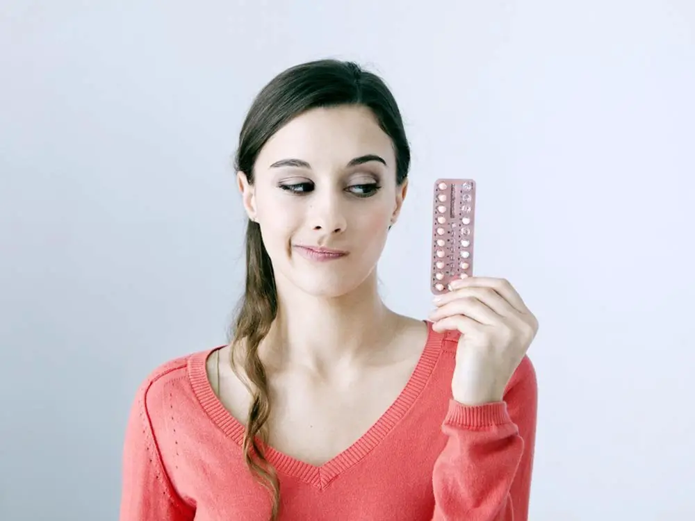 امرأة تحمل حبوب منع الحمل