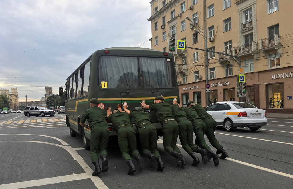 جنود روس يدفعون شاحنة صغيرة