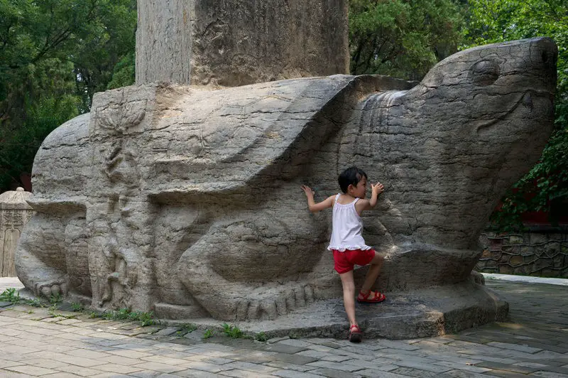 فتاة تقف بجانب (بيكسي) في معبد (داي) في (شاندونغ) بالصين.