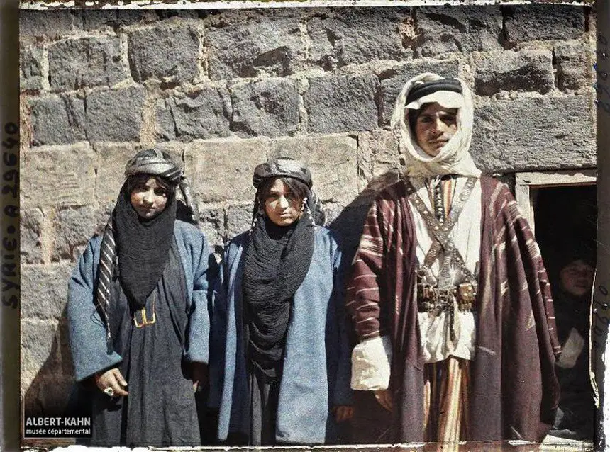صورة تظهر الزي التقليدي العربي في بلدة تل شهاب السورية لكل من الرجال والنساء، حيث يظهر في الصورة أختان برفقة زوج إحداهما سنة 1921