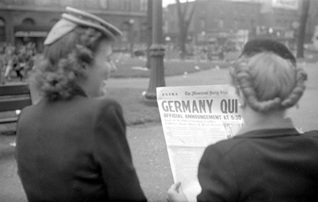 شابتان تمسكان بجريدة في كندا حيث تم الاعلان عن سقوط ألمانيا النازية ونهاية الحرب العالمية الثانية. صورة: BAnQ/Wikimedia Commons