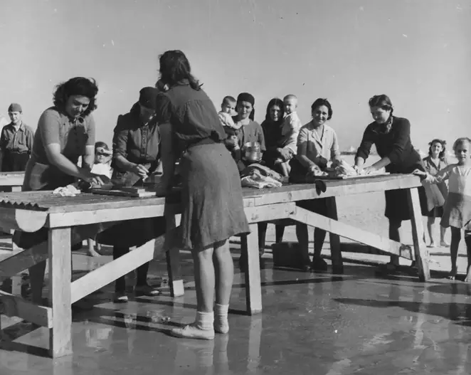صورة التُقطت سنة 1945 من مخيم الشط في مصر تظهر بعض النسوة يغسلن ثيابهن في الخارج. صورة: United Nations Archives