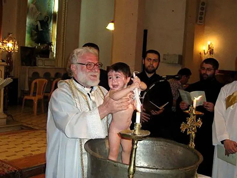 سر المعمودية لأحد الأطفال في كنيسة السريان كاثوليك في حمص. صورة: موقع eSyria
