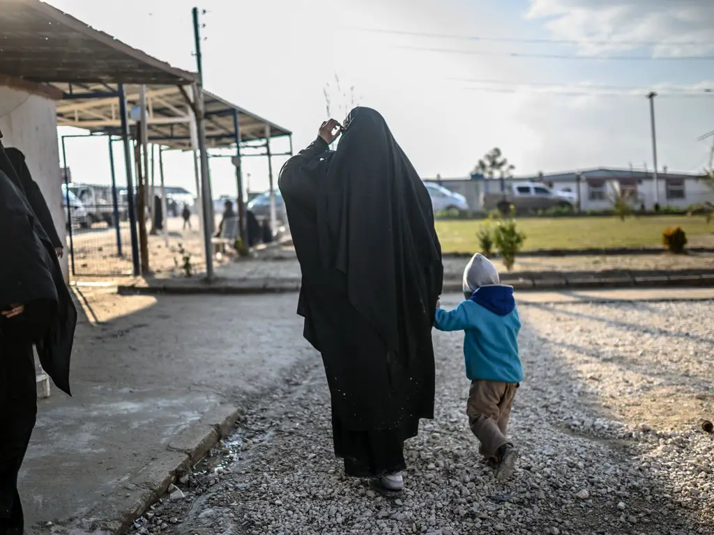 واحدة من المرأتين الفرنسيتين اللتين هربتا من آخر جيوب تنظيم داعش في سوريا تتمشى برفقة طفلها في مخيم الهول للاجئين في الشمال الشرقي لسوريا في 17 فبراير 2019: