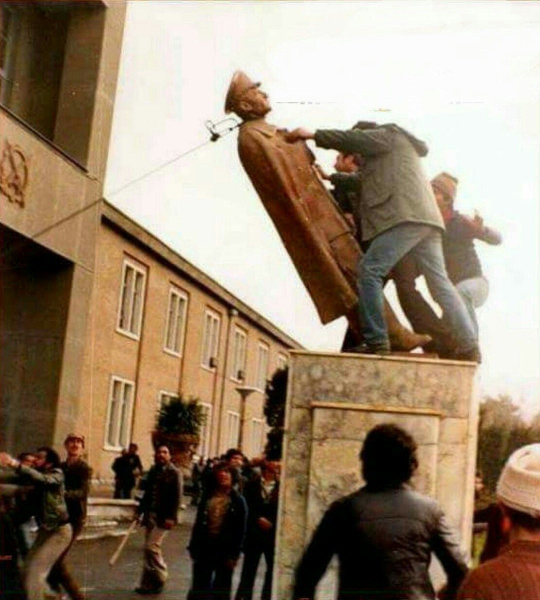 متظاهرون يسقطون تمثالا للشاه.
