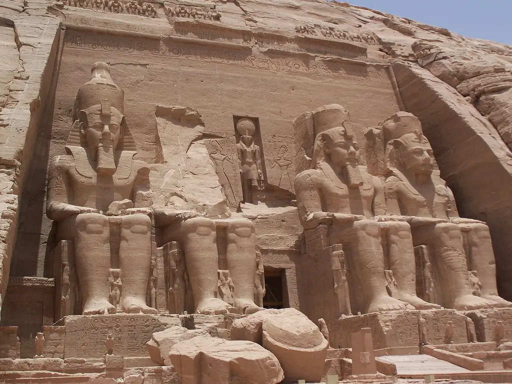 مدخل المعبد الكبير: تبرز في هذه الصورة التماثيل الأربعة الضخمة ويُلاحظ تماثيل أصغر حجماً تمثّل أفراداً من عائلة رمسيس الثاني