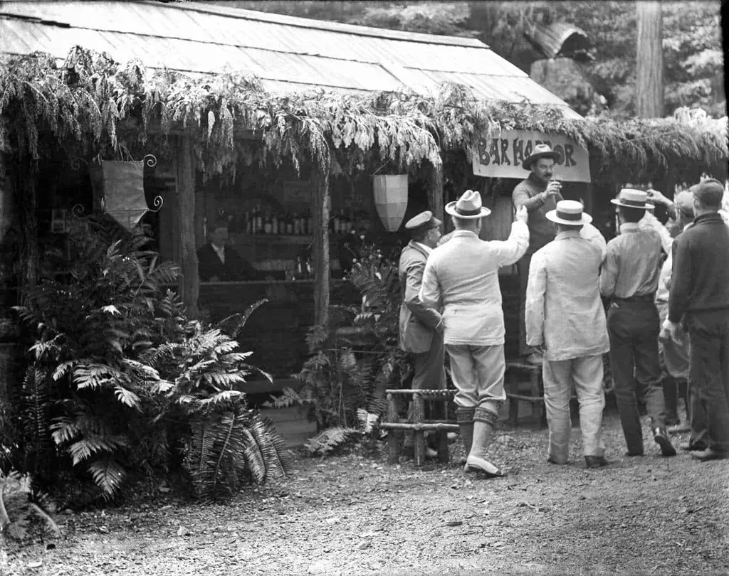 رجال يشربون نخباً خارج حانة (بار هاربور)، في البستان البوهيمي.