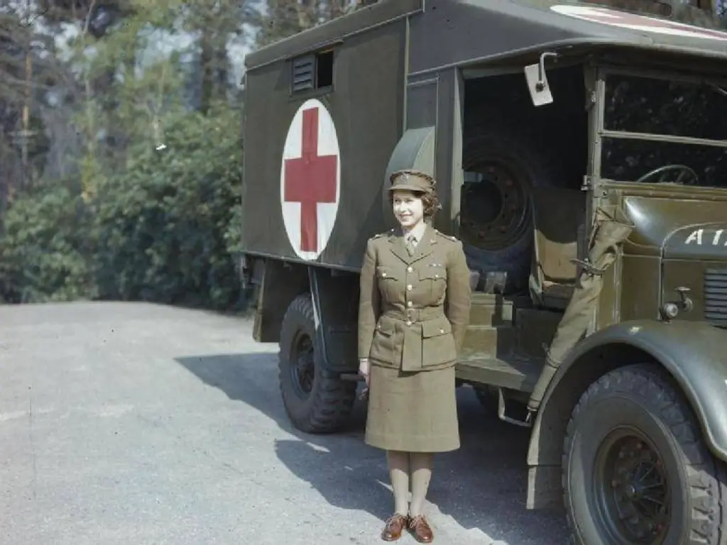الأميرة (إيليزابيث) في زيها الرسمي التابع لقوات خدمة المساعدة الإقليمية واقفة أمام سيارة إسعاف.