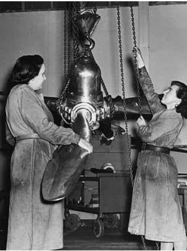 في هذه الصورة ترفع امرأتان مروحة تشغيل آلة كبيرة بريطانية في شهر مارس سنة 1942.