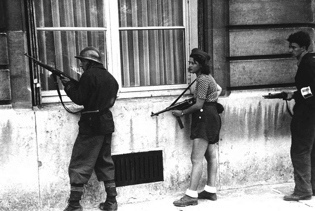 فتاة في صفوف حركة المقاومة وعضو في دورية للمقاومة تمشط شوارع باريس لإخراج بقايا فلول القناصين الألمان في التاسع والعشرين أغسطس 1944.