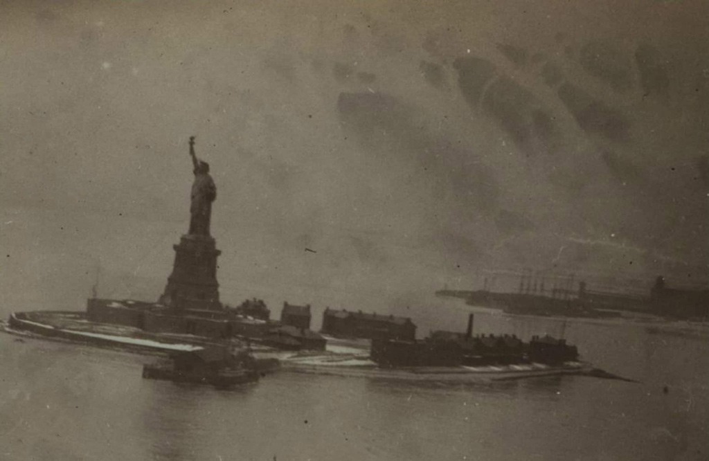 تمثال الحرية في سنة 1912، على يمين خلفية الصورة جزيرة (بلاك طوم).