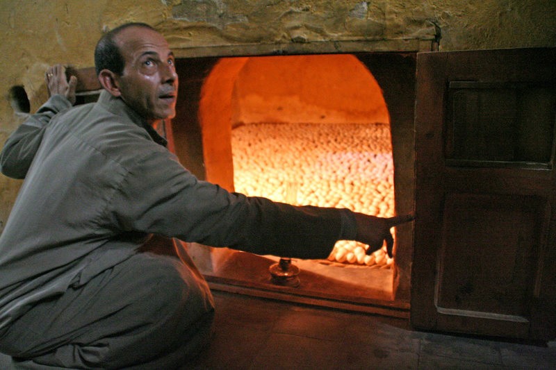 عامل مصري في إحدى المفرخات المصرية القديمة وهو يستخدم مصابيح البنزين لتدفئة البيض.