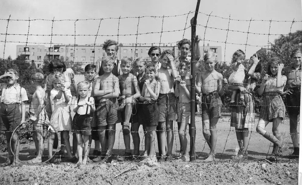 أطفال من ألمانيا الغربية يقفون خلف سياج المطار