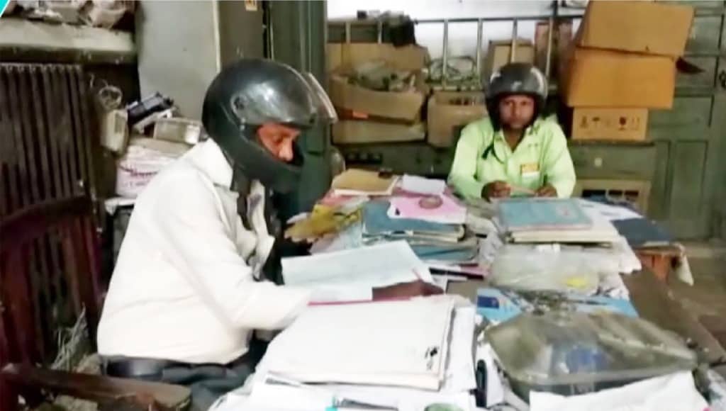 موظفون يرتدون خوذات داخل مكاتبهم في الهند