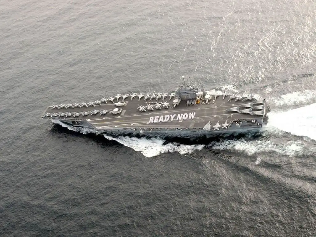 سفينة حربية تابعة للبحرية الأمريكية تحمل رسالة ”جاهزون الآن“ مكتوبة على سطحها.