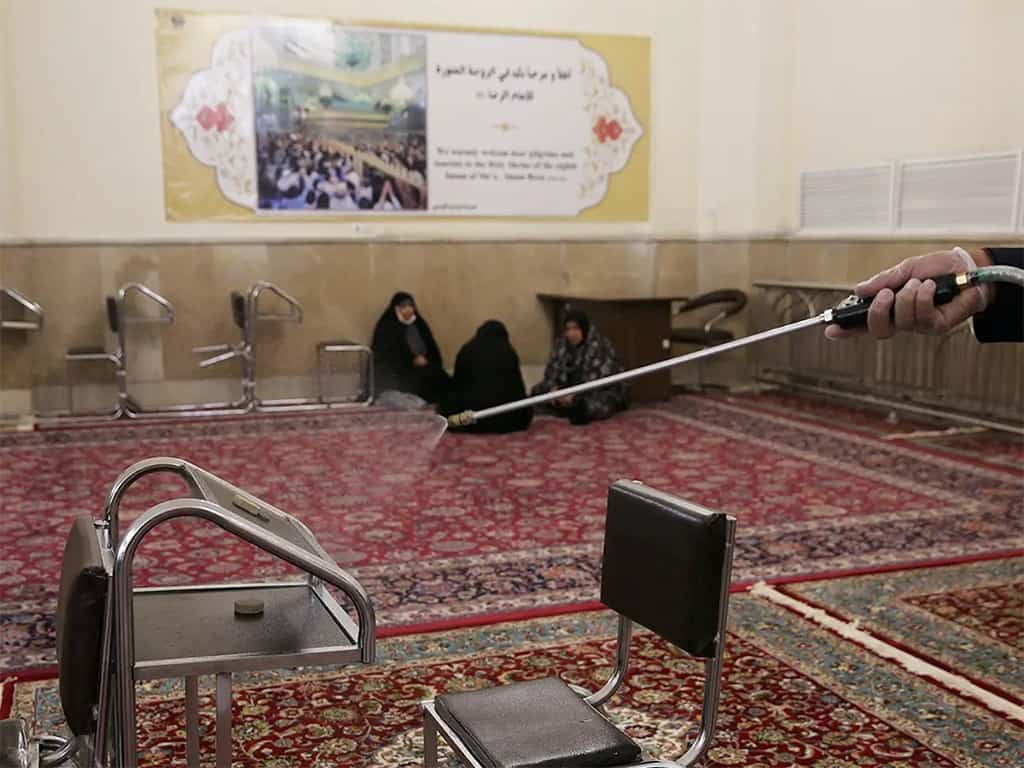 أحد أفراد الفرق الطبية وهو يرش المواد المعقمة لتطهير المناطق الداخلية لمقام الإمام رضا المقدس في مشهد، بإيران يوم 27 فبراير الفارط.