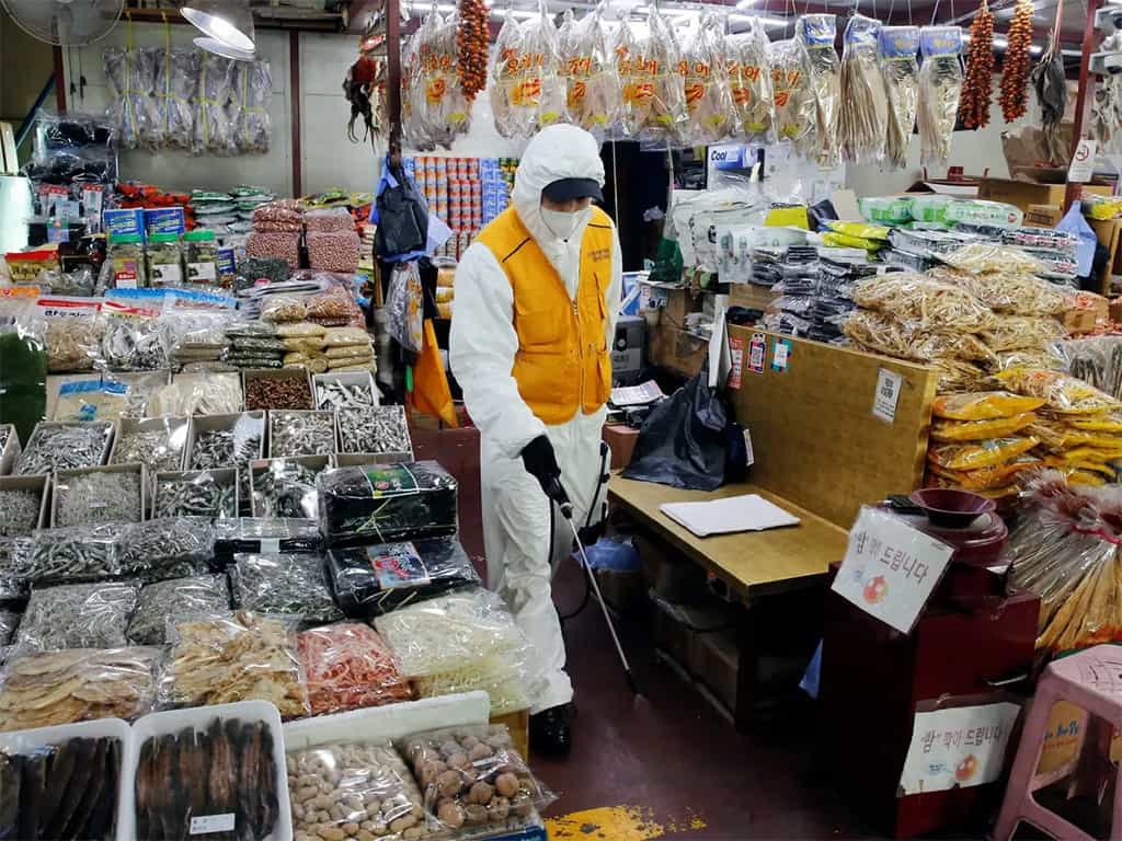 موظف ينتمي لمصلحة تنظيف وتطهير يعقم أحد الأسواق في العاصمة سيول.
