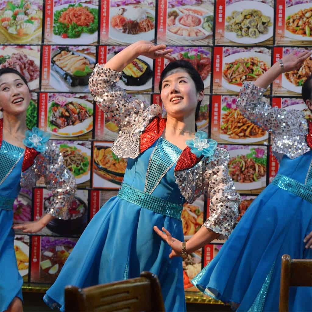 نادلات كوريات شماليات يقدمن عروضاً ترفيهية لزبائن أحد مطاعم (بيونغ يانغ) في الصين.