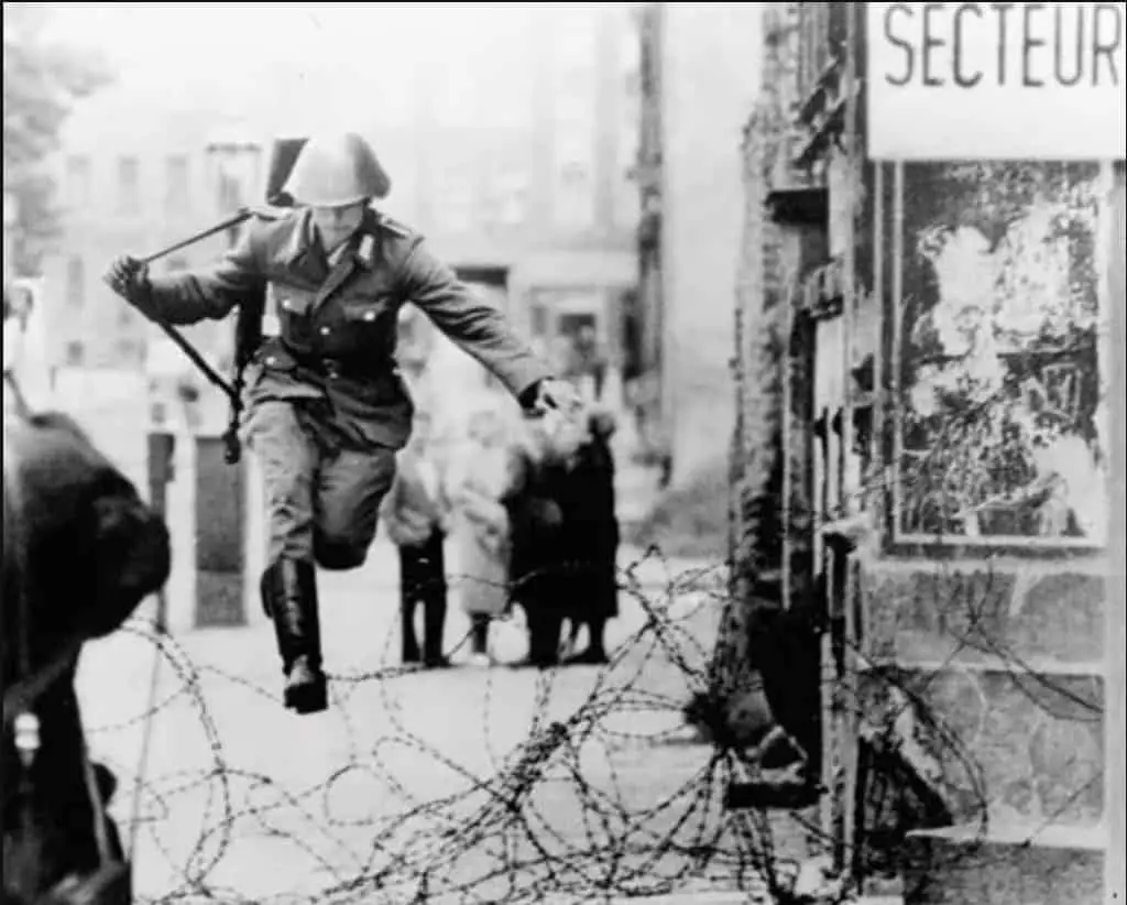 جندي من ألمانيا الشرقية يثب فوق سياج للالتحاق بعائلته في برلين الغربية قبل فوات الأوان. في أغسطس سنة 1961.