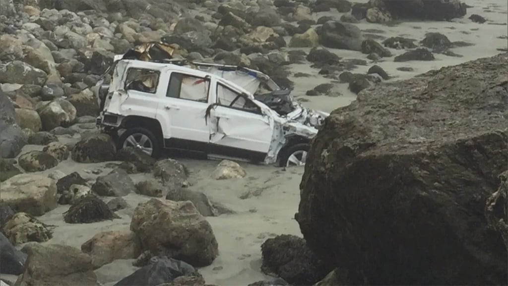 سيارة الـJeep الخاصة بالسيدة (هيرنانديز) بعد أن لفظتها أمواج البحر إلى شاطئ صخري.